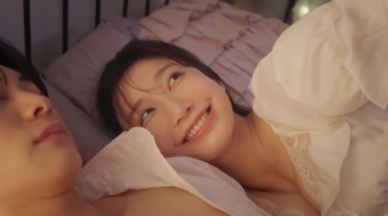 ベッドでパートナーを見つめる女性