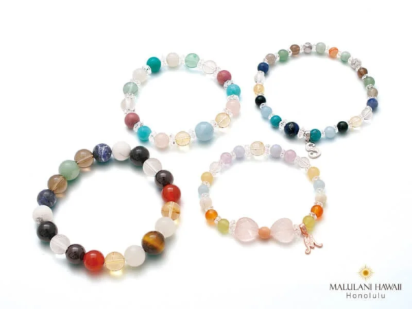 様々な色合いの天然石やビーズで作られた4つのブレスレット