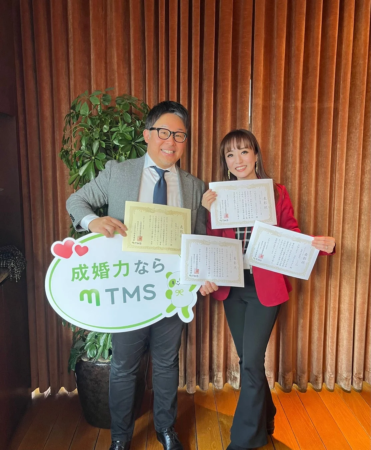 mTMSのロゴと表彰状を手に笑顔の男女