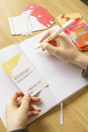 ノートに書き込む手とカード