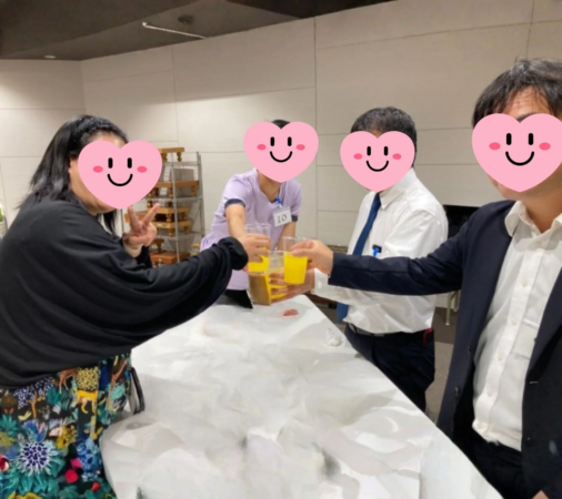複数の人々が飲み物を持って乾杯している瞬間の写真です。和やかな雰囲気で、楽しそうな交流の場であることがうかがえます。