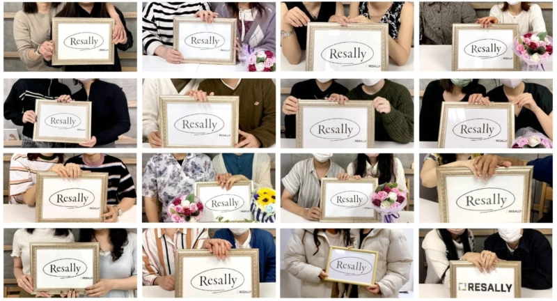 Resallyのロゴが入った額縁を持つ人々の集合写真
