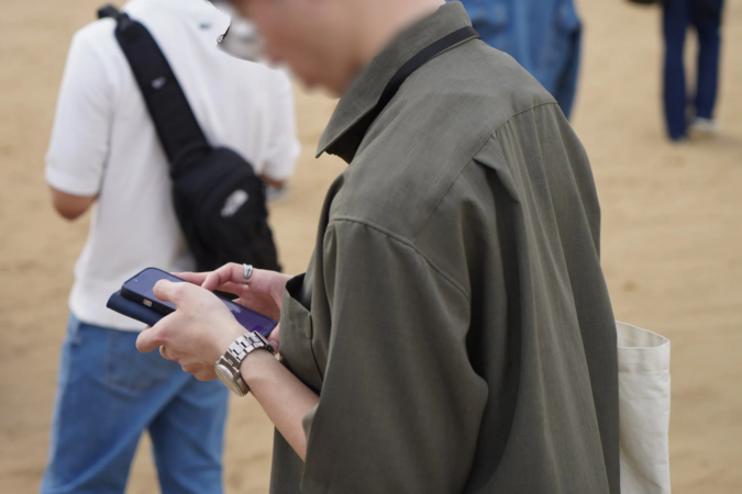 スマートフォンを操作する人物