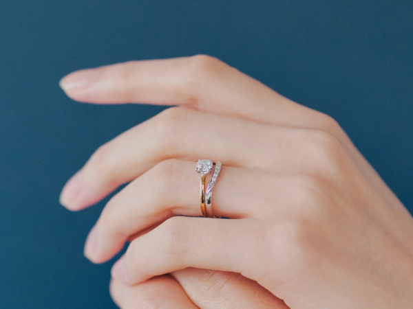 女性の指に重ね付けされた婚約指輪と結婚指輪